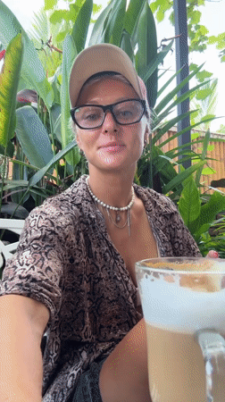 Woman enjoys late night coffee outdoors in snake-print shirt