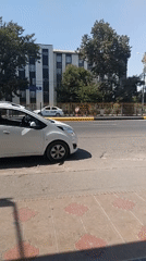 White Chevrolet parked near NAB building on a quiet city street