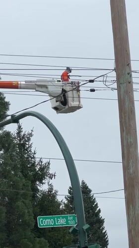 Utility worker performs overhead line maintenance in Coquitlam