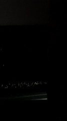 Nighttime aerial view shows city lights from airplane window