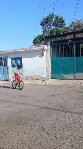 Cyclist performs wheelies on residential street in Porlamar, Venezuela