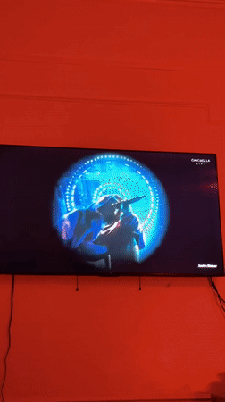 Coachella Live broadcast shows hooded rapper performing under blue spotlight