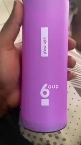 A hand holds a purple, cylindrical container. The container has the word "6 oup" printed on it, with the "6" being slightly larger than the "oup." A white label reading "six oup" is affixed vertically above the printed text. The speaker says, "water is life, yeah."