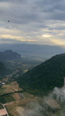 Hot air balloons drift over Hong Ngern Village's green valleys