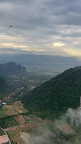 Hot air balloons drift over Hong Ngern Village's green valleys