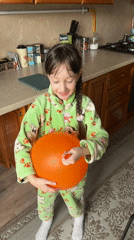 Girl plays indoors while cat interactions happen outside