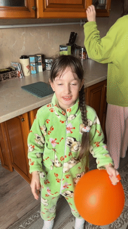 Girl plays indoors while cat interactions happen outside