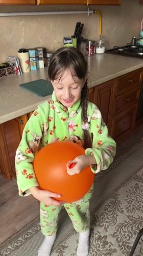 Girl plays indoors while cat interactions happen outside
