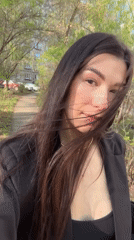 Woman in black blazer observed on sidewalk in Chaikovsky