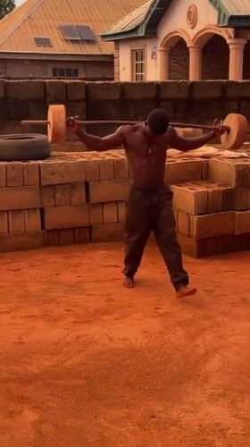 Man performs improvised weightlifting workout in Bukuru backyard