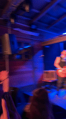 Band performs to energetic crowd under blue stage lights
