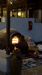 Woman tends outdoor brick oven in Sharm El Sheikh