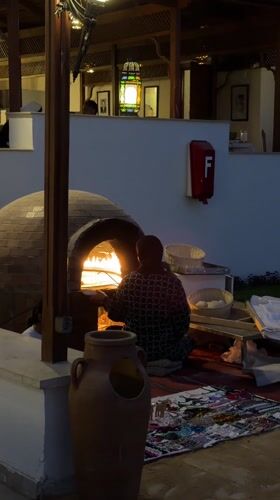 Woman tends outdoor brick oven in Sharm El Sheikh