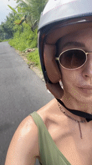 Woman rides scooter through tropical Tegallalang, Indonesia countryside