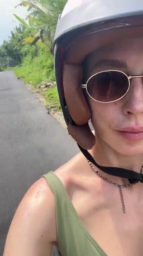 Woman rides scooter through tropical Tegallalang, Indonesia countryside