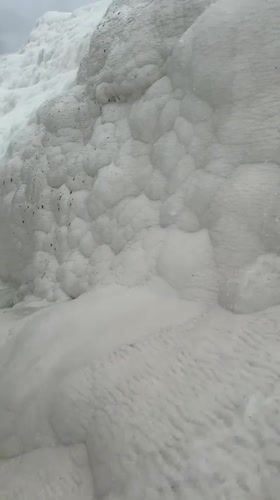 Morning visitors wade through Pamukkale's white travertine terraces