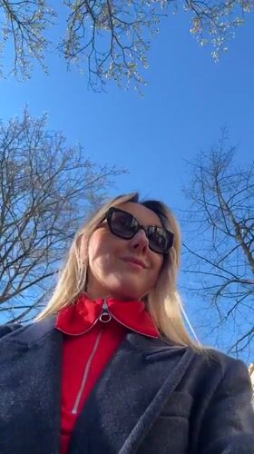 Woman films outdoor selfie video in sunny Riga