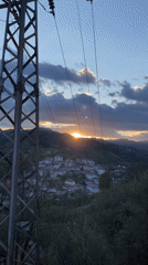 Spring sunset documented over Bulgarian mountain village with sleeping cat