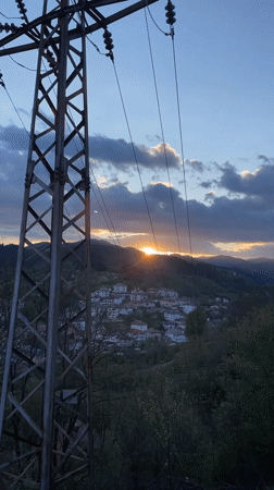 Spring sunset documented over Bulgarian mountain village with sleeping cat