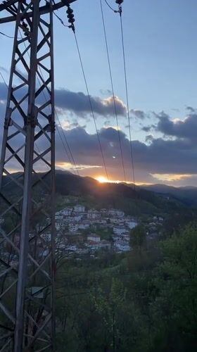 Spring sunset documented over Bulgarian mountain village with sleeping cat