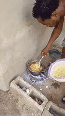 Man cooks spaghetti outdoors in Keffi, Nigeria residential area