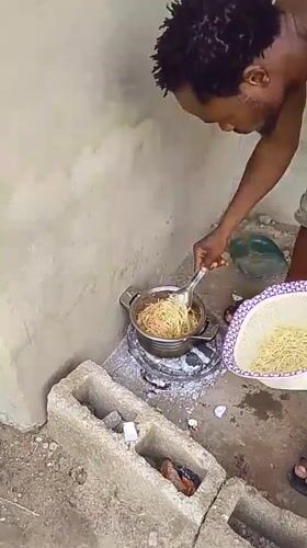 Man cooks spaghetti outdoors in Keffi, Nigeria residential area