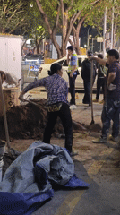 Woman shovels dirt on sidewalk in Yuzhong District