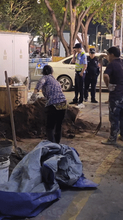 Woman shovels dirt on sidewalk in Yuzhong District