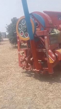 Morning farm work captured around threshing machine in Pakistan