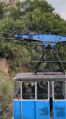 Tbilisi cable car passes mural-covered Brutalist apartment block