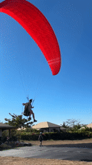 Paragliders fill the sky above Kuta Selatan's coastal cliffs