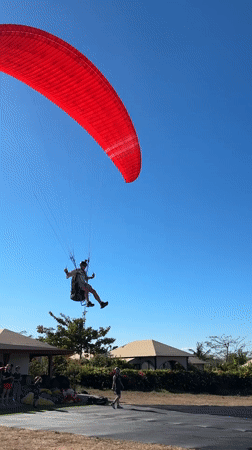 Paragliders fill the sky above Kuta Selatan's coastal cliffs