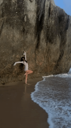 Woman practices yoga poses on Ahungalla beach, Sri Lanka