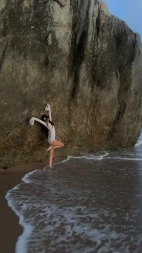 Woman practices yoga poses on Ahungalla beach, Sri Lanka