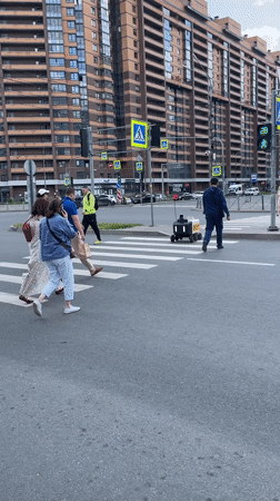 Daily life continues in Murino with pedestrians and delivery robots
