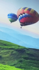 Hot air balloons spotted over green hills in Kenya