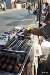 Chocolate-filled cylinder cakes cooking on a street vendor's pan