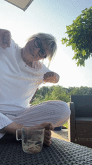 Woman in pajamas playfully poses on patio table in France