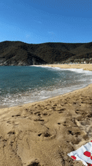 A quiet Greek beach morning with kitesurfing and coastal scenery