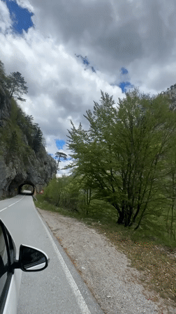 Car navigates narrow mountain road near tunnel in Montenegro