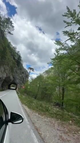 Car navigates narrow mountain road near tunnel in Montenegro