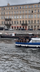 Tour boats and canal life along a cloudy Saint Petersburg morning