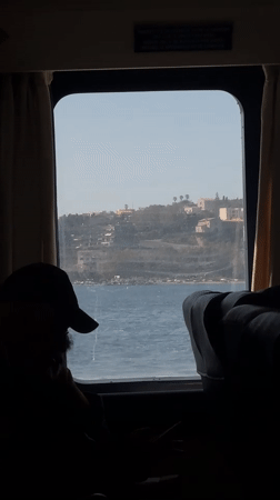 Passenger observes Mediterranean coastline from boat near Milazzo