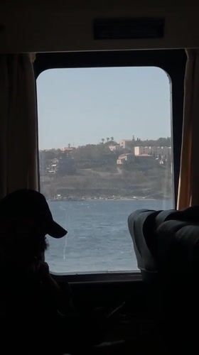 Passenger observes Mediterranean coastline from boat near Milazzo