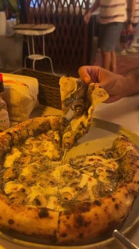 Diner enjoys mushroom pesto pizza at Baan Mae Nam restaurant