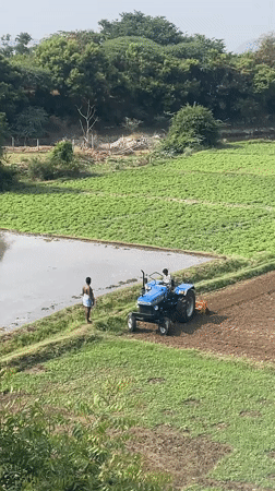 Early morning tractor tills flooded fields in rural India