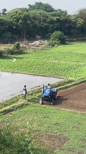 Early morning tractor tills flooded fields in rural India