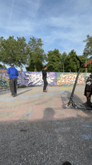 Young men perform scooter tricks, socialize at Lyon skatepark