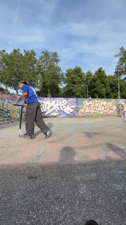 Young men perform scooter tricks, socialize at Lyon skatepark