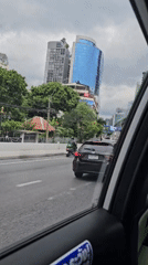 Bangkok street traffic with distinctive architecture in the background